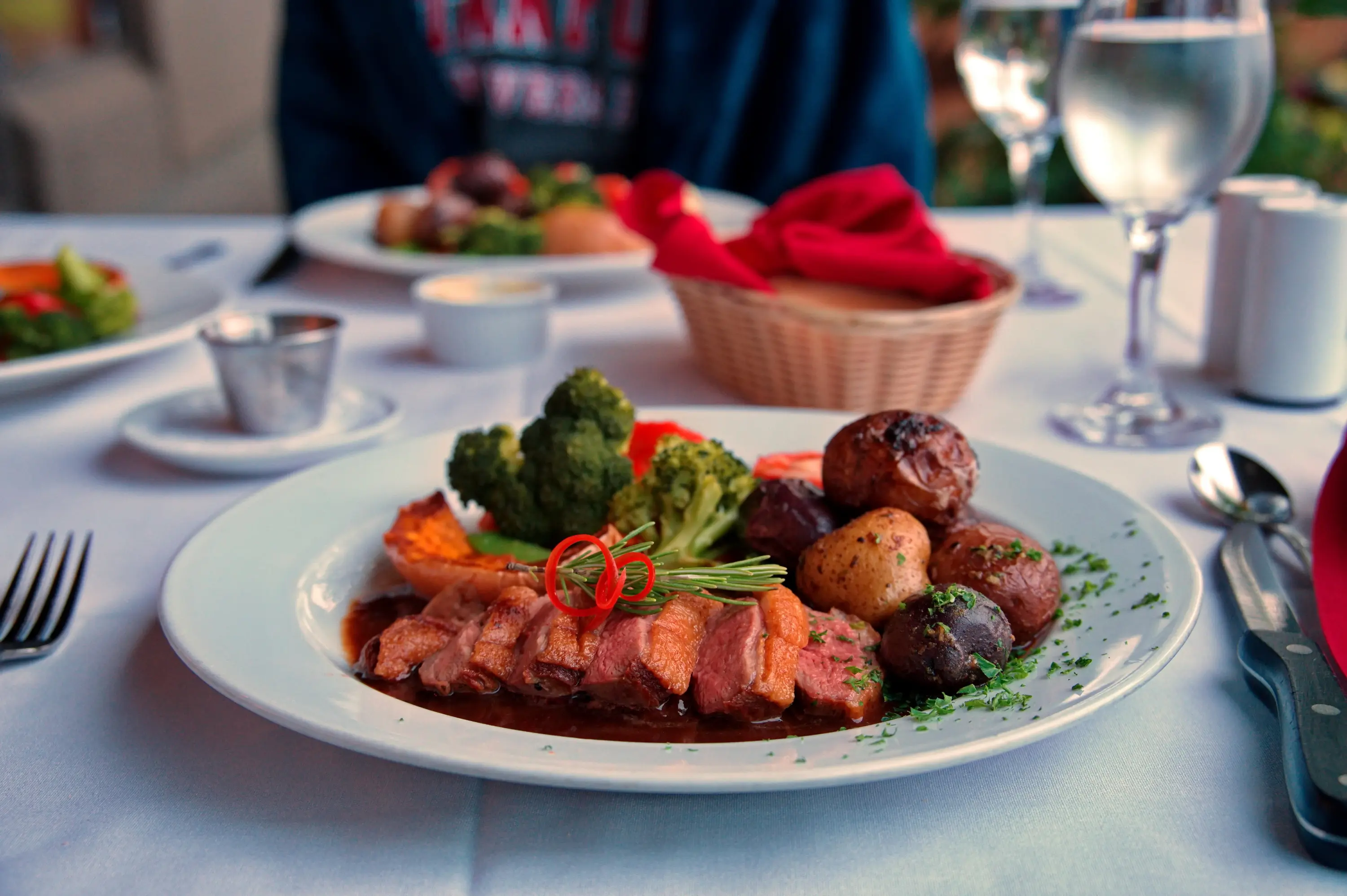 Prato de carne com legumes numa mesa posta