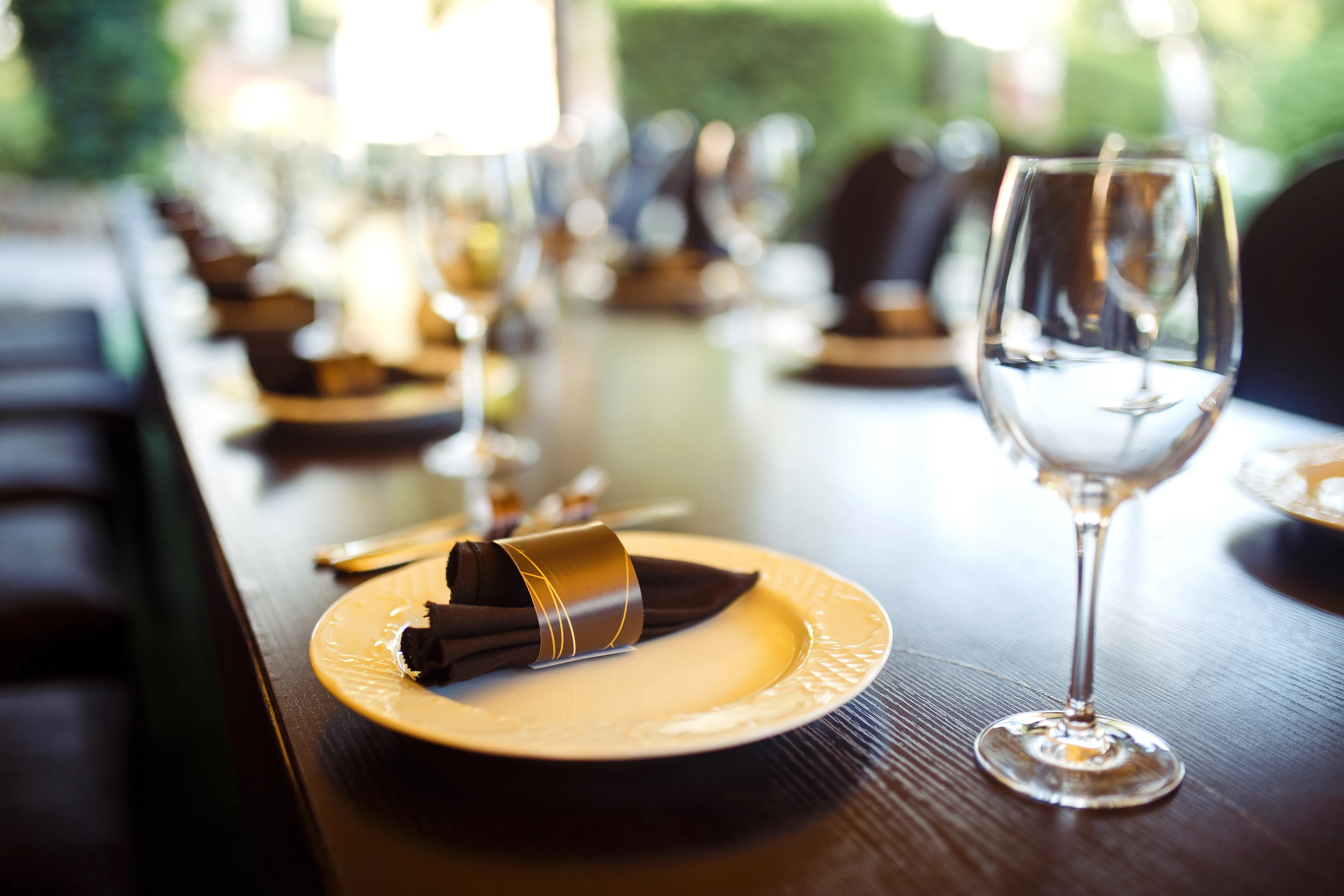 Mesa posta com copos de vinho, pronta para receber